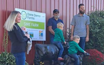 family standing by farm sign